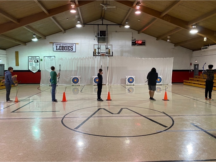 five students aiming their bows